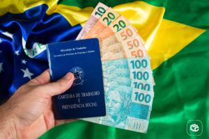 Carteira de Trabalho e notas de Real sobre bandeira do Brasil